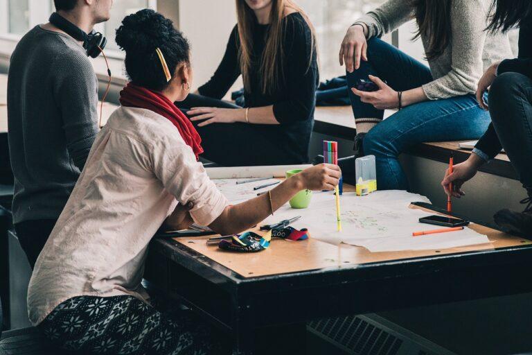 Give people sitting around a desk having a conversation.
