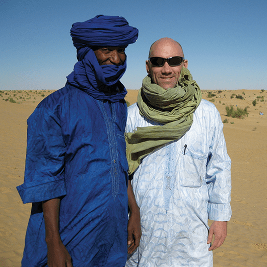 two men stand in the desert