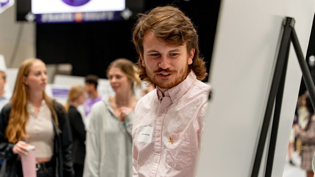 Man gestures at poster