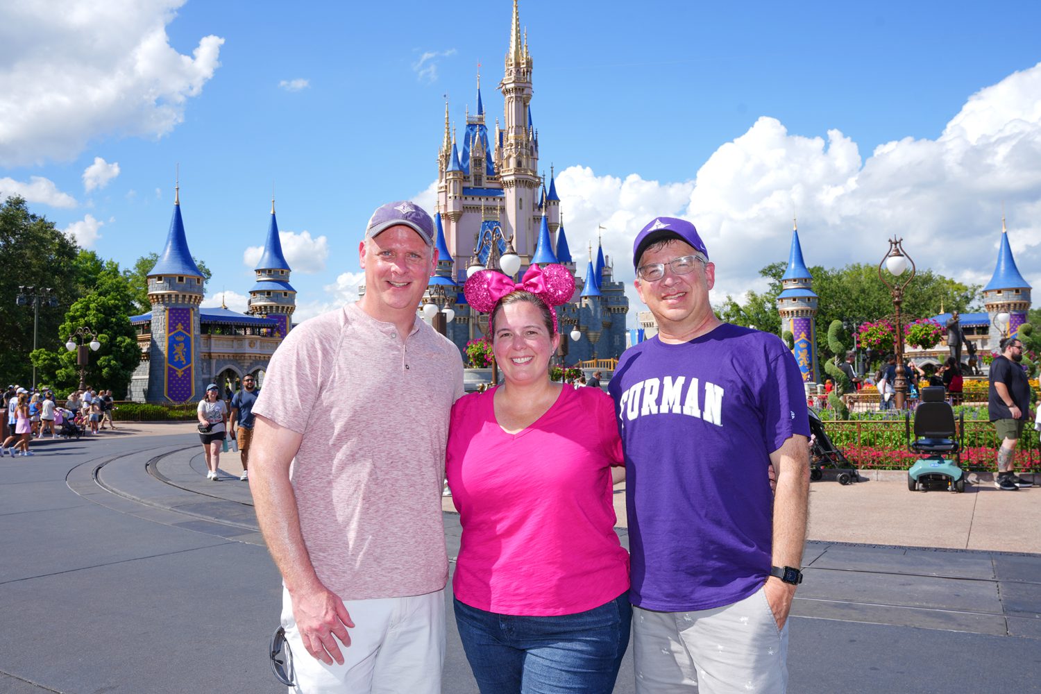 Furman math professors, from left, Kevin Hutson, Liz Bouzarth and John Harris pose for a photo in the Magic Kingdom at Disney World. Photo by Nathan Gray, Furman University.