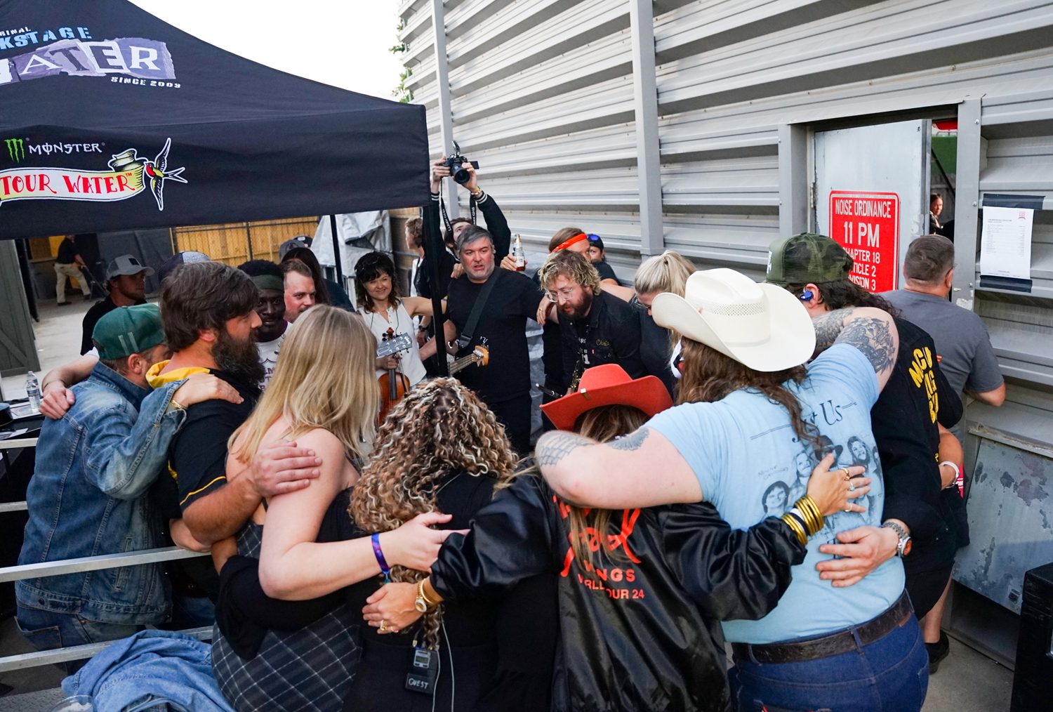 Marcus King, right, gathers backstage with members of his band, regional musicians, and friends and family before performing at the Marcus King Family Reunion at the CCNB Amphitheatre at Heritage Park on Sunday, August 25, 2024. Photo by Nathan Gray, Furman University