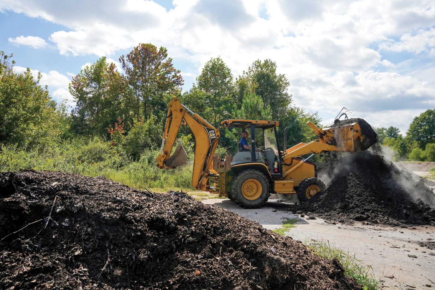 Bruce Adams, manager of the Furman Farm at The Shi Institute for Sustainable Communities, operates a backhoe to turn piles of compost at an off-campus compositing site on September 19, 2024. Photo by Nathan Gray