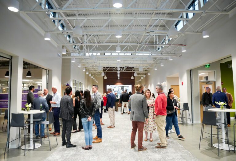 People network inside a bright, large open hall with cocktail tables and chairs.