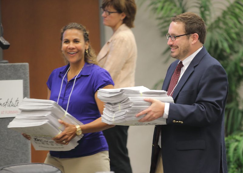Erin Johnson and Alan Hancock distribute copies of The A Team's activity book.