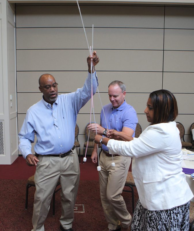 AD Williams, Jeff Stevens and Michelle Hunt work together to submit the STEM Stars' tower for judging.