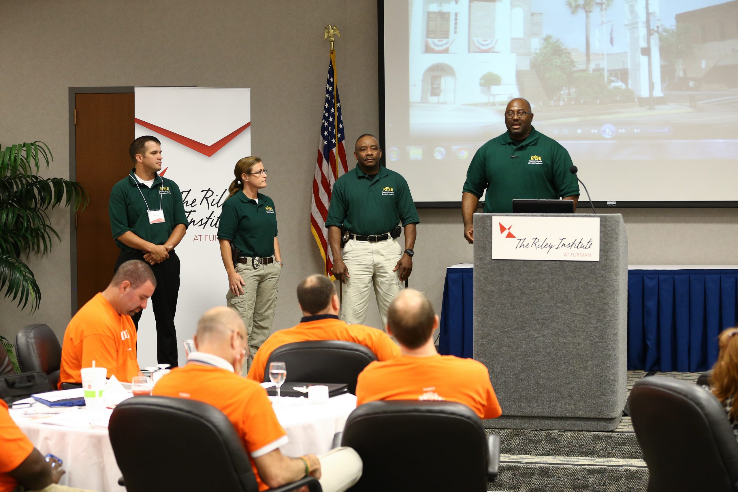Johnathan Guildes speaking, team members (l-r) Jonathan James, Selena Small and Reggie Hill, Horry: RISE (Respect, Integrity, Service, Excellence)