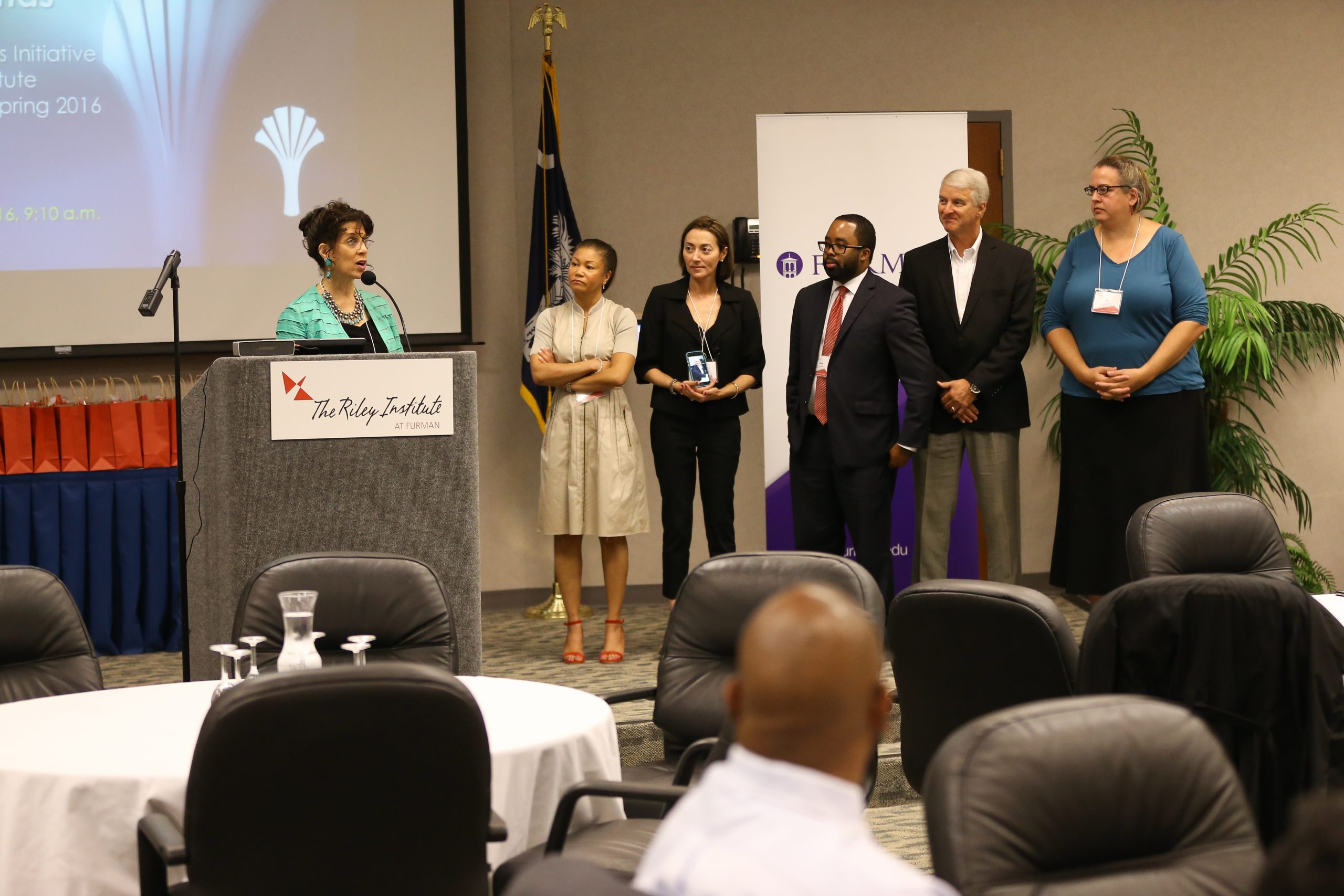 Katherine Davis speaking. Team members (l-r) Pam Baker, Tara Nauful, Mark McLawhorn, Randy Senn and Jen Morrison, Flashes of Hope - Midlands