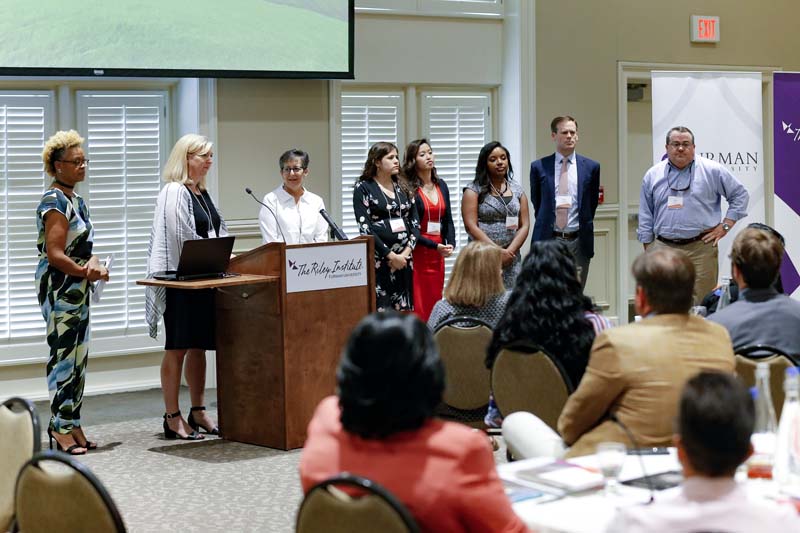 (l-r) Felicca Smith, Sally Wills speaking, Ellen Stevenson, Sally Morris Cote, Judy Pham, Miranda Asson, Ansel Sanders and Gary Daniels, H.E.A.L.