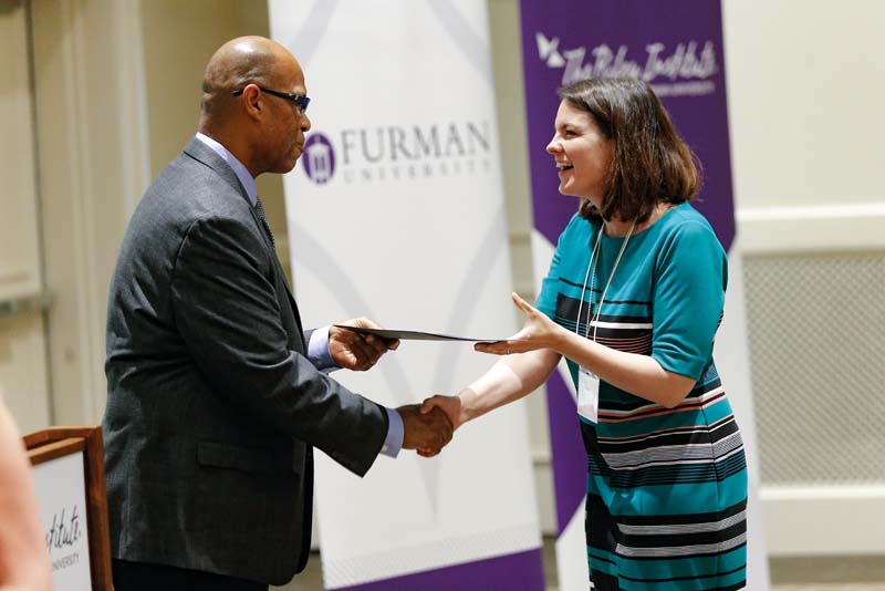 Gina Blohm, DLI Carry On Crew, receiving her Riley Fellow certificate from Juan Johnson