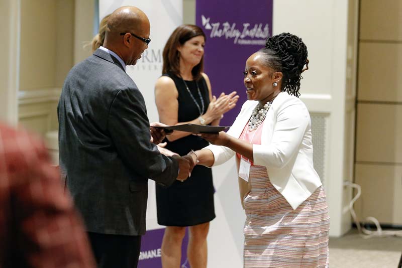 Mary Garvey, DLI Carry On Crew, receiving her Riley Fellow certificate from Juan Johnson