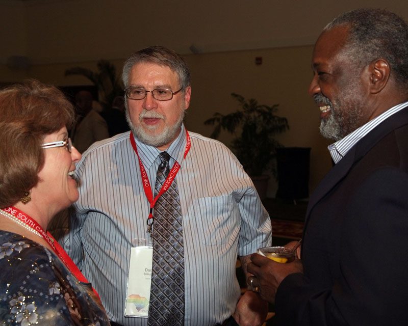 (l-r) Raye and Dan Nilius speaking with Roland Gardner