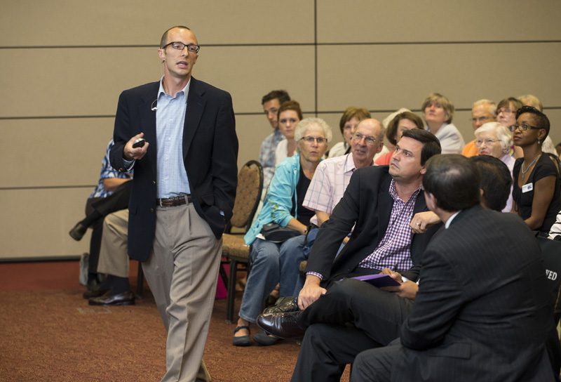 Dr. Longest asking the audience how the single mom's monthly salary was budgeted.