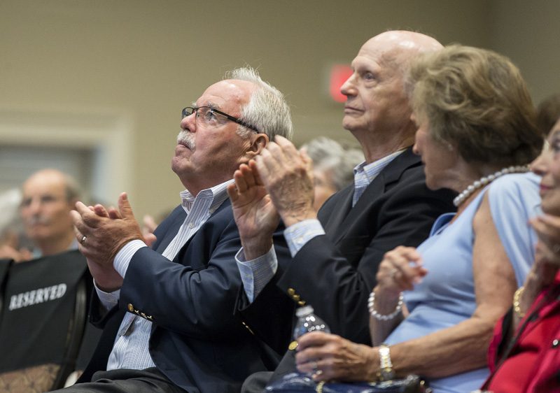 Jim Sinegal and Secretary Riley applaud after Carol Naughton's address