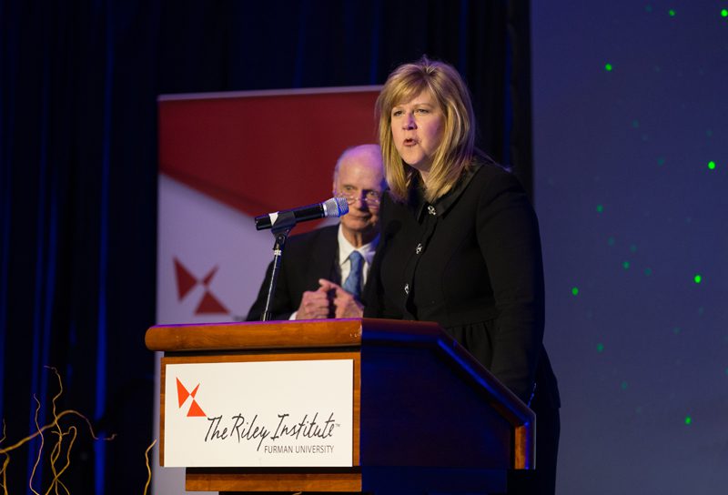 Elizabeth Davis welcoming Secretary Riley to the stage