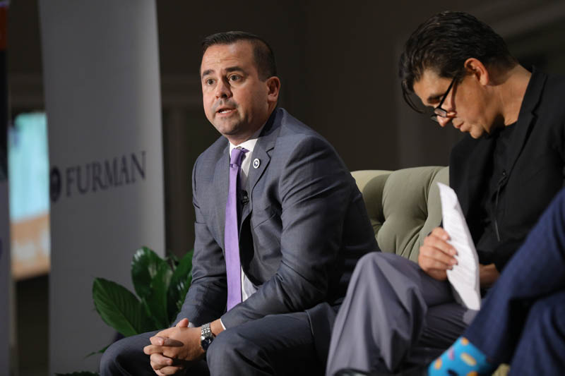 (l-r) Neal Collins speaking and Akan Malici