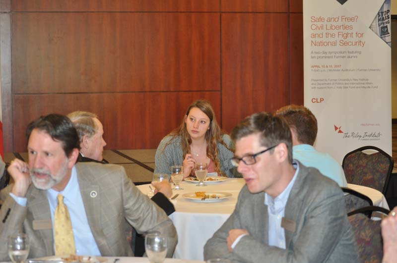 Forefront: Michael Roosevelt and Eli Dourado; Rear: Vice Admiral Mike McConnell, U.S. Navy, ret., Furman class of 1966, former U. S. Director of National Intelligence, speaking with Advance Team member Emma DeVenny