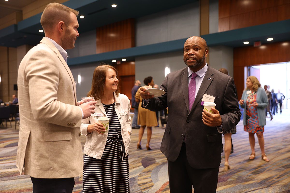 Michael Williamson, president and CEO of Northside Development Group, and Mitch Kennedy, assistant city manager of City of Spartanburg, speak with an eventgoer prior to the start of the event.