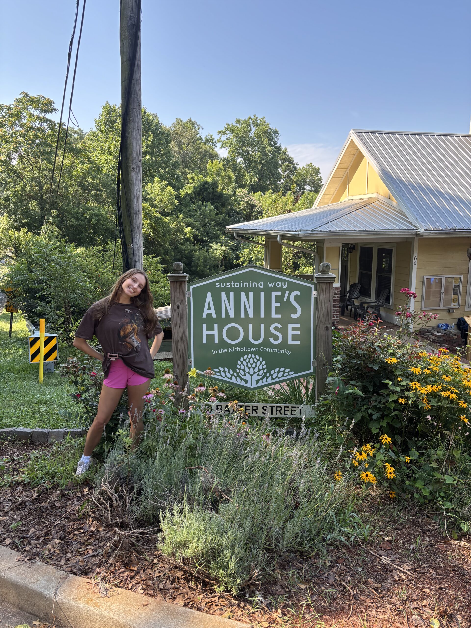 Hannah Rowan standing beside the Annie's House sign