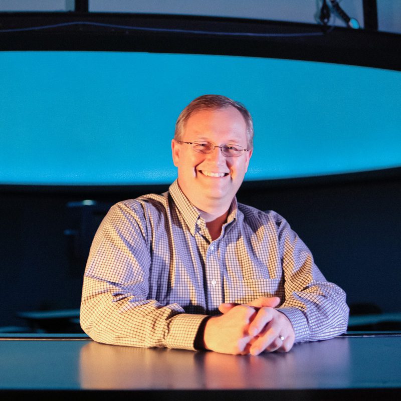 Dr. Moffett, with the dome of the Timmons Planetarium in the background.